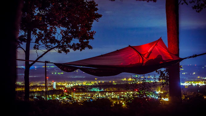 Tree tent in front of a beautiful view over Skövde in night lights.