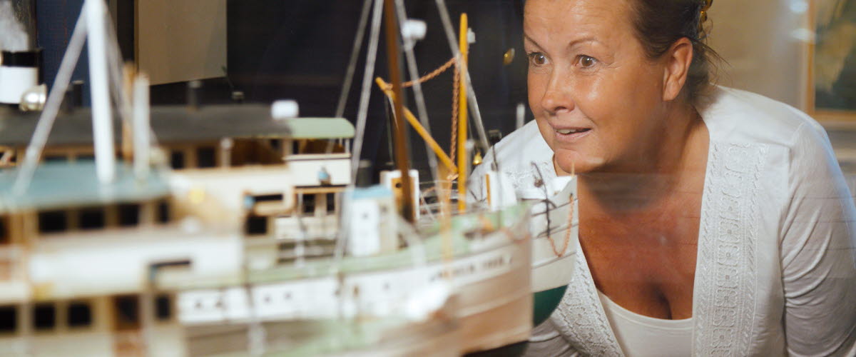 Besökare tittar på modeller av gamla båtar på Kanalmuseet i Sjötorp.