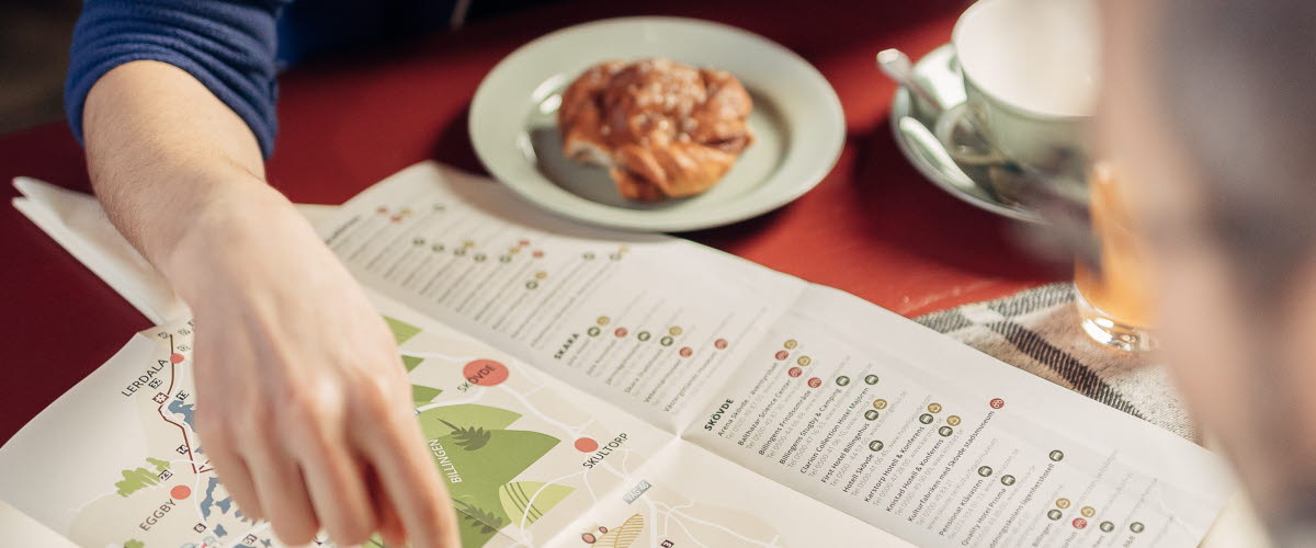 Två människor planerar sin vandring över en fika.