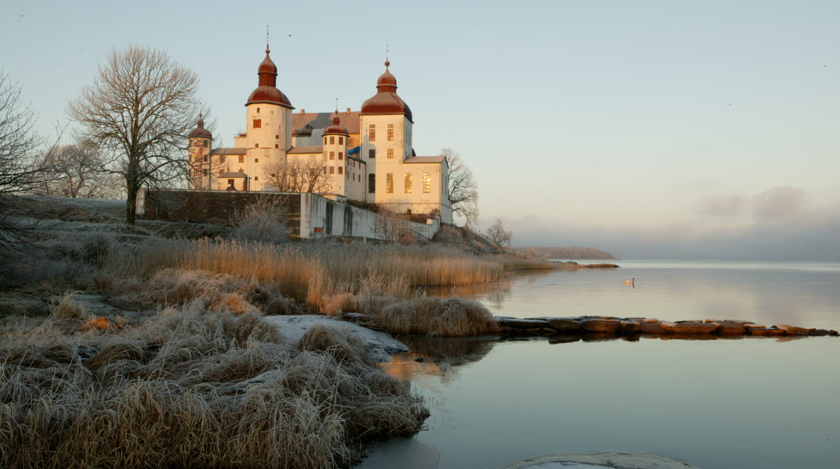 A white castle by a lake in a winter landscape