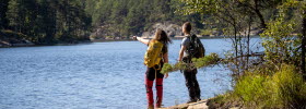 Two persons with backpacks at a lake