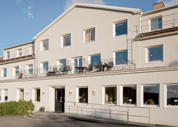 En närbild på en vitputsad husfasad med massor av fönster.