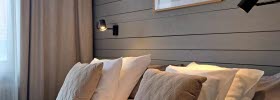 Hotelroom with two beds against a wall of grey wooden panel.