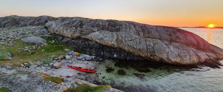 Kajak uppdragen på en sandstrand i vacker solnedgång