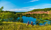 Two women are walking with their dogs and have just taken a break from a large quarry.