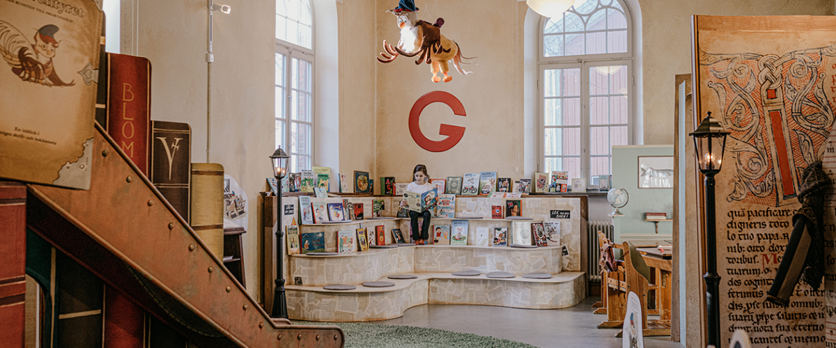 bild inne på bokäventyret en flicka som läser bok