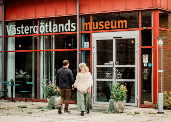 Två personer går mot en entré till ett museum.