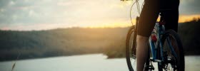 Person standing on his bike with a view over a lake