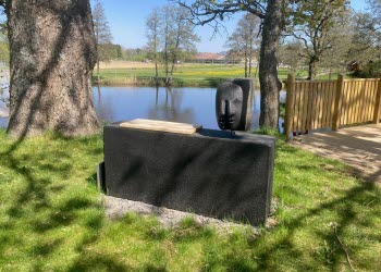 En svart skulptur som ser ut som ett huvud på en låda.