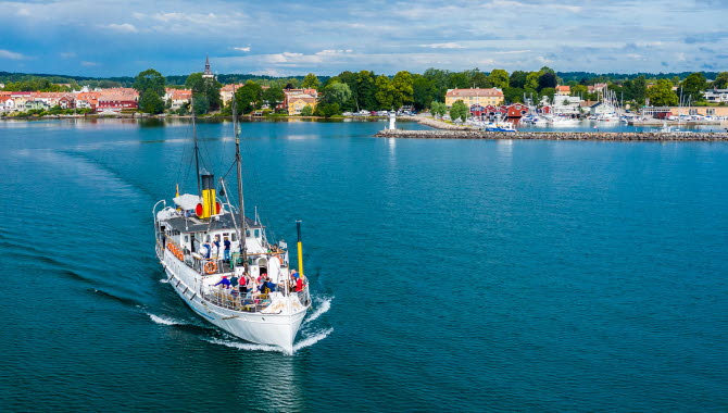 Ångaren Trafik lämnar Hjo och beger sig ut på Vättern, med Hjo stad i bakgrunden.