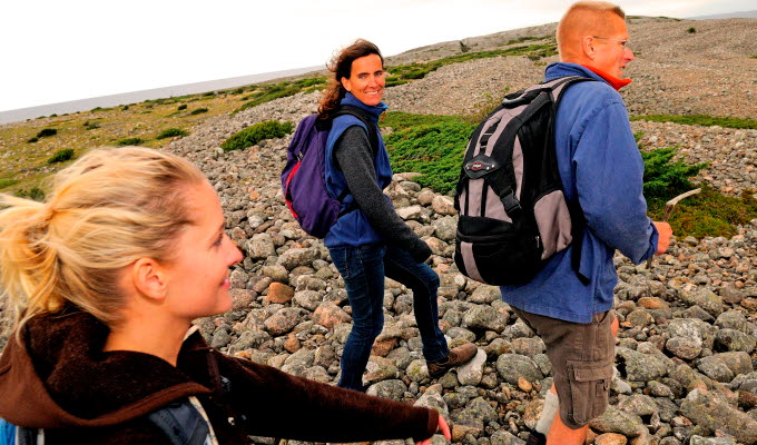 Tre personer vandrar över ett klapperstensfält på Kosteröarna.