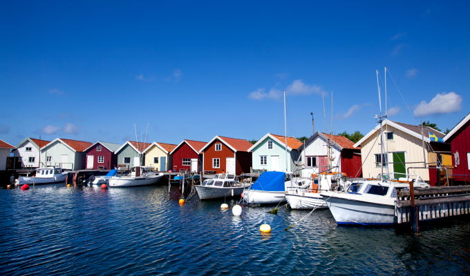 Färgglada sjöbodar med ankrade småbåtar vid bryggorna på Nordkoster.
