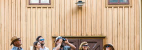 A group of tourists photographing wooden houses in Hjo. 