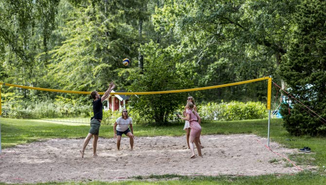 Fyra personer spelar beachvollyeboll