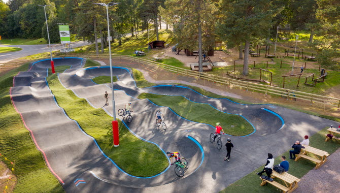 En pumptrackbana full med mountainbikecyklister