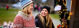 Två tjejer promenerar på julmarknad