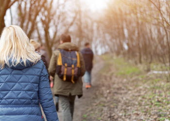 En bild på en grupp människor som promenerar i vårsolen