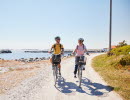 Two people are cycling on an island.