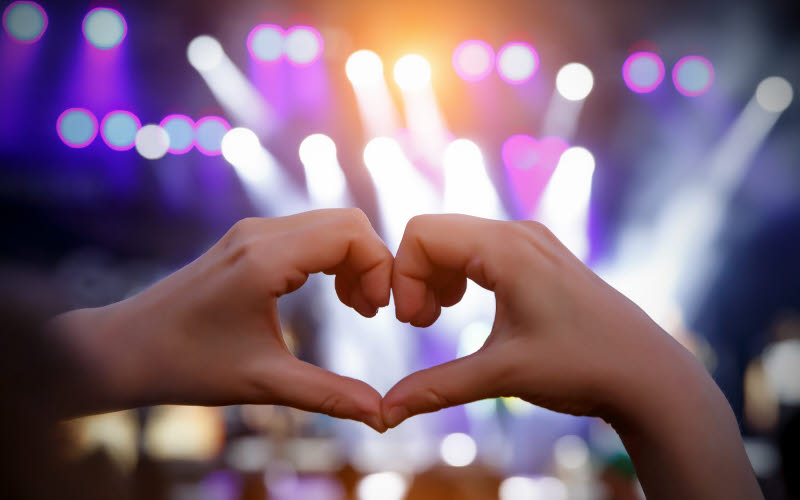 Två händer som bildar ett hjärta på ett evenemang