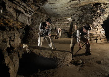 Tre äldre män som står och gräver i  Qvarstensgruvan. 