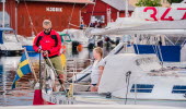 Two people on a sailing yacht in Hjo harbour. 