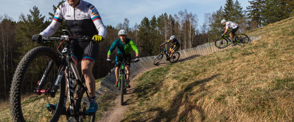 Personer som cyklar mountainbike i skogen