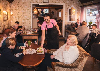 Servitris serverar en räkmacka på ett café