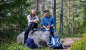 Två personer sitter på en sten i skogen.