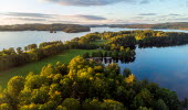 Drone image over the forest by a lake.