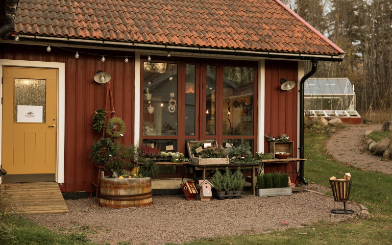 Charmig gårdsbutik med rödmålad fasad och  utomhusdekoration