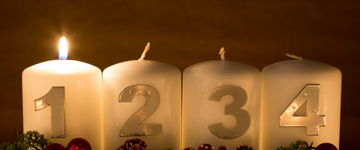 Ett adventsljus tänt av fyra.