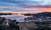 Vy över Bottnafjorden med Gerlesborg i förgrunden vid skymning. Rosa-lila himmel