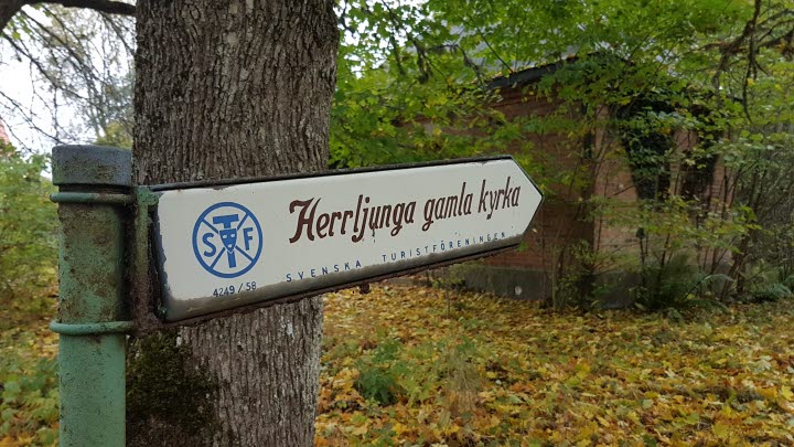 Sign that shows direction towards Herrljunga old church