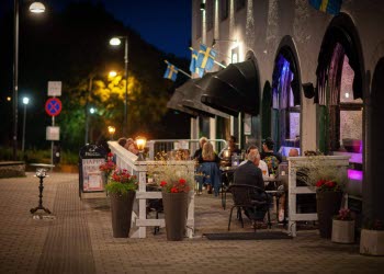 En bild tagen från gatan på en uteservering utanför en restaurang