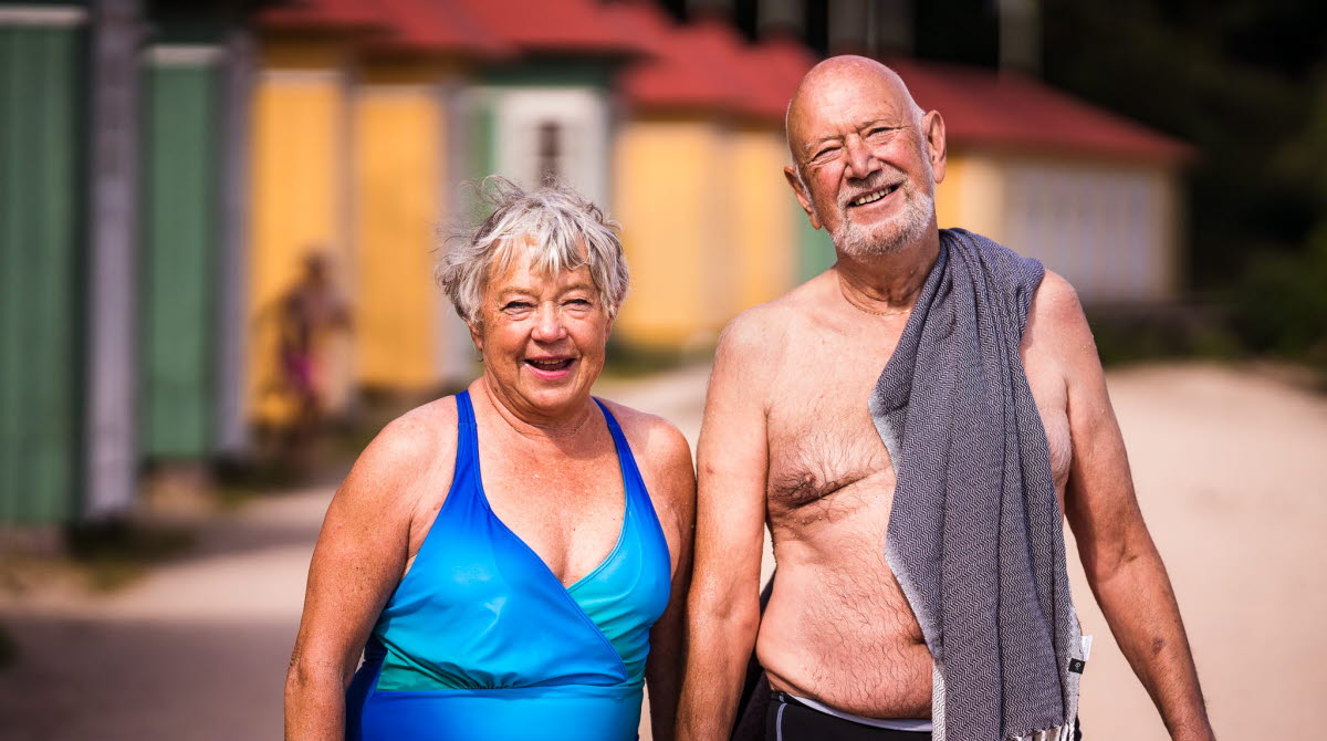 Äldre par vid Guldkroksbadets sandstrand i Hjo. 