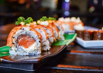 En närbild på sushi som ligger snyggt presenterat på ett fat.