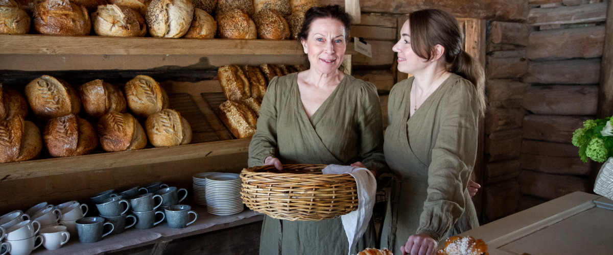 Två kvinnor i ett bageri bakom disken