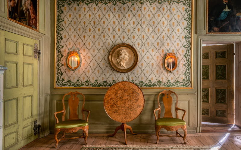 Interiör bild på två gamla stolar och ett gammalt bord.