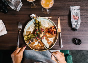 Någon äter från en tallrik med mat på