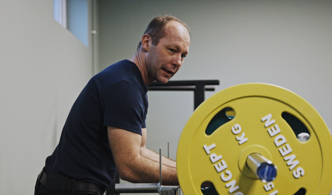man står vid en vikt på gym