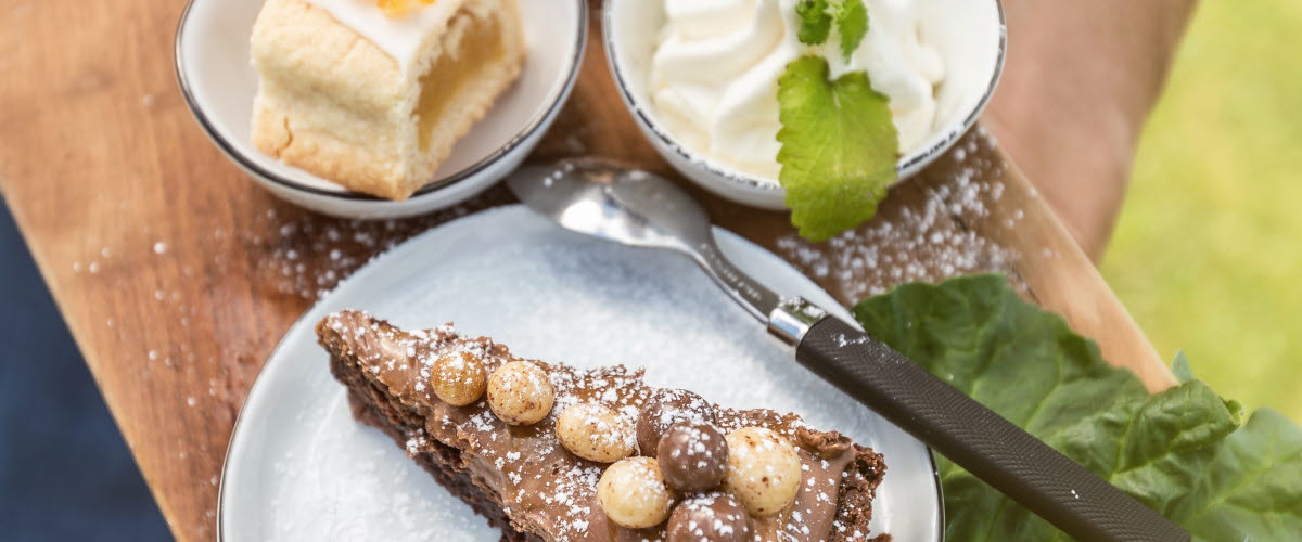 Kladdkaka, bulle och en kaka på en träbräda.