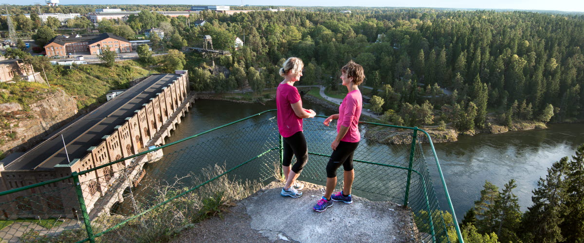 Två kvinnor som står vid utsiktspunkten Kopparklinten med utsikt över Göta älv.