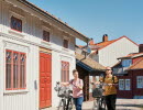 Two people are cycling in a small town.