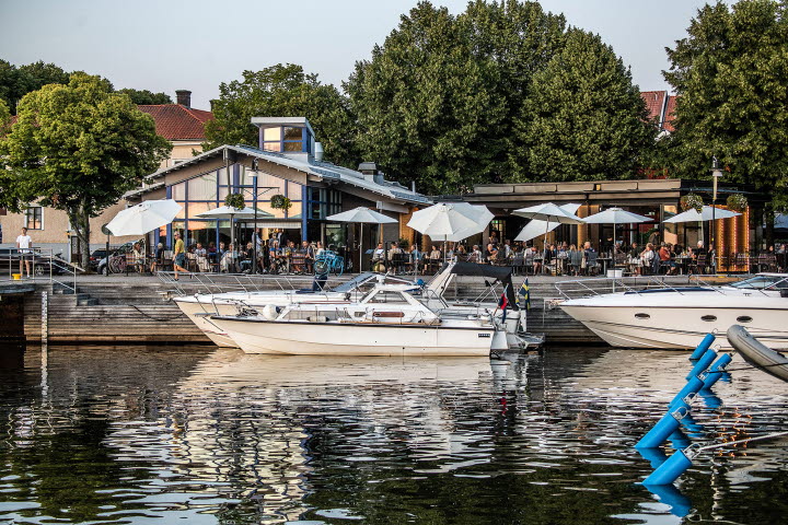 Exteriörbild av restaurang Sill och Dynamit från sjösidan med gästhamnen och båtar i förgrunden.