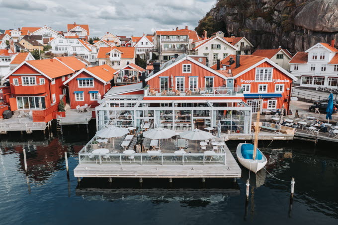 Drönarbild från sjösidan över Bryggan Fjällbacka med skärgårdssamhället i bakgrunden.