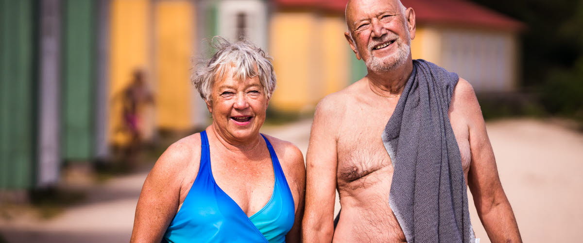 Äldre par vid Guldkroksbadets sandstrand i Hjo. 