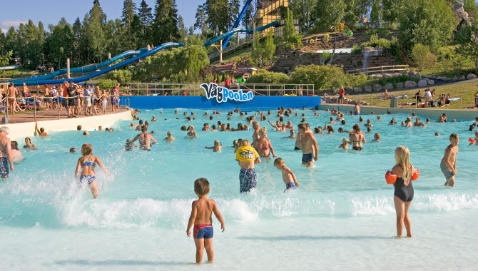 Barn som badar i vågpoolen på sommarland.
