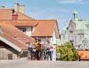 Två personer cyklar i en småstad.