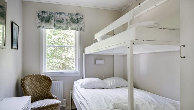 A room with a white bunk bed
