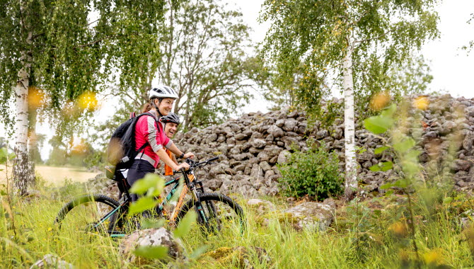Två cyklister vid ett stort stenröse.
